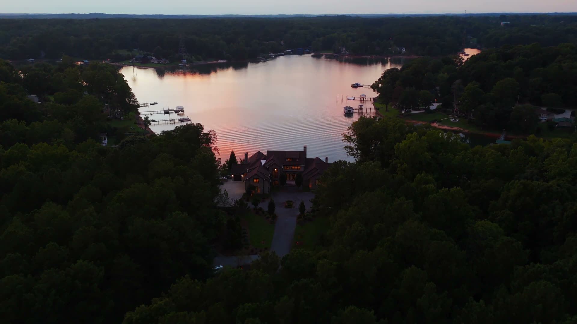 125 Quiet Waters Dr and its shoreline from the air, at dusk.