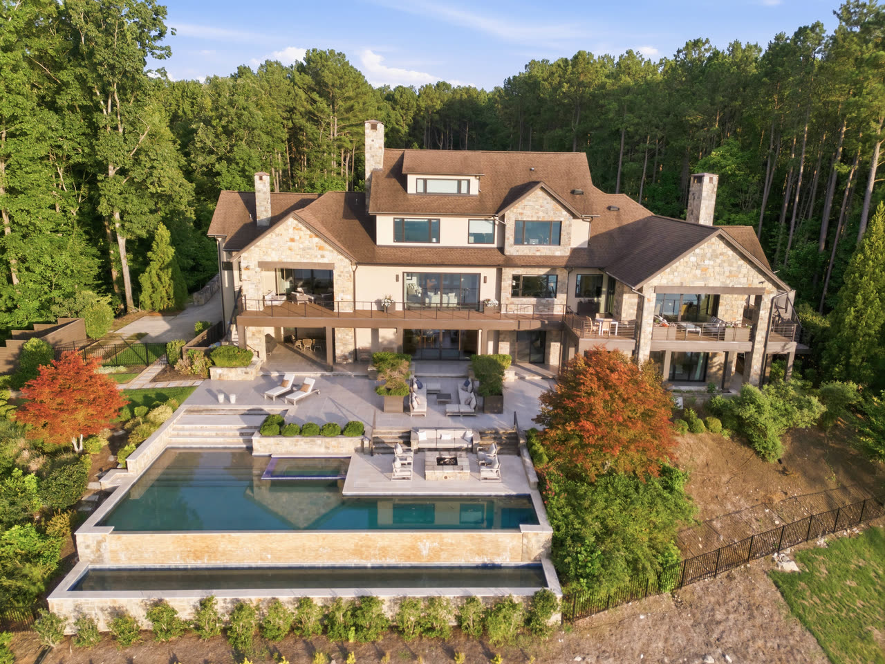 Aerial view of the rear of the house with the infinity pool and terraces above the water.