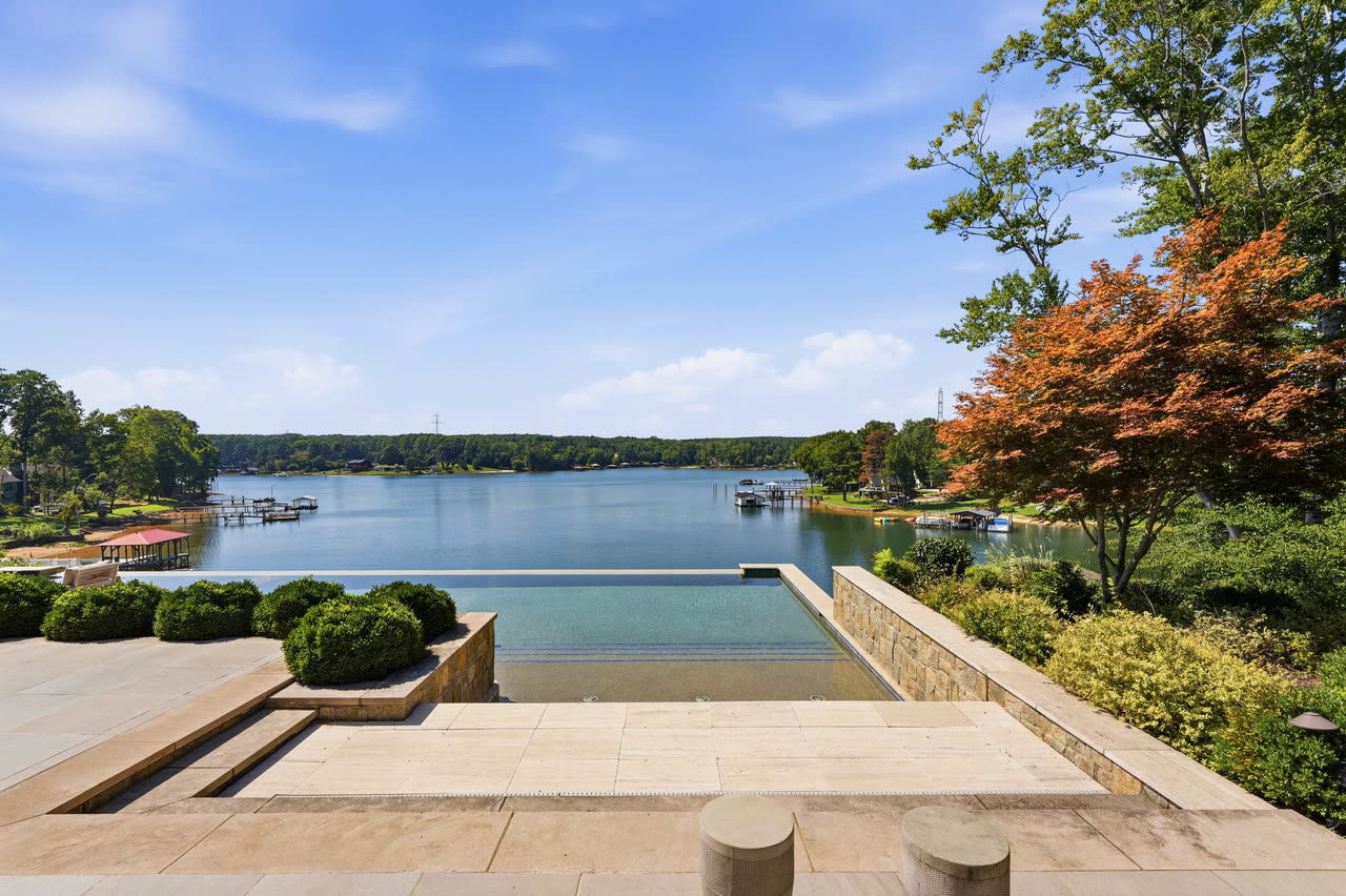 The infinity edge of the pool level with the lake, with the shoreline beyond.