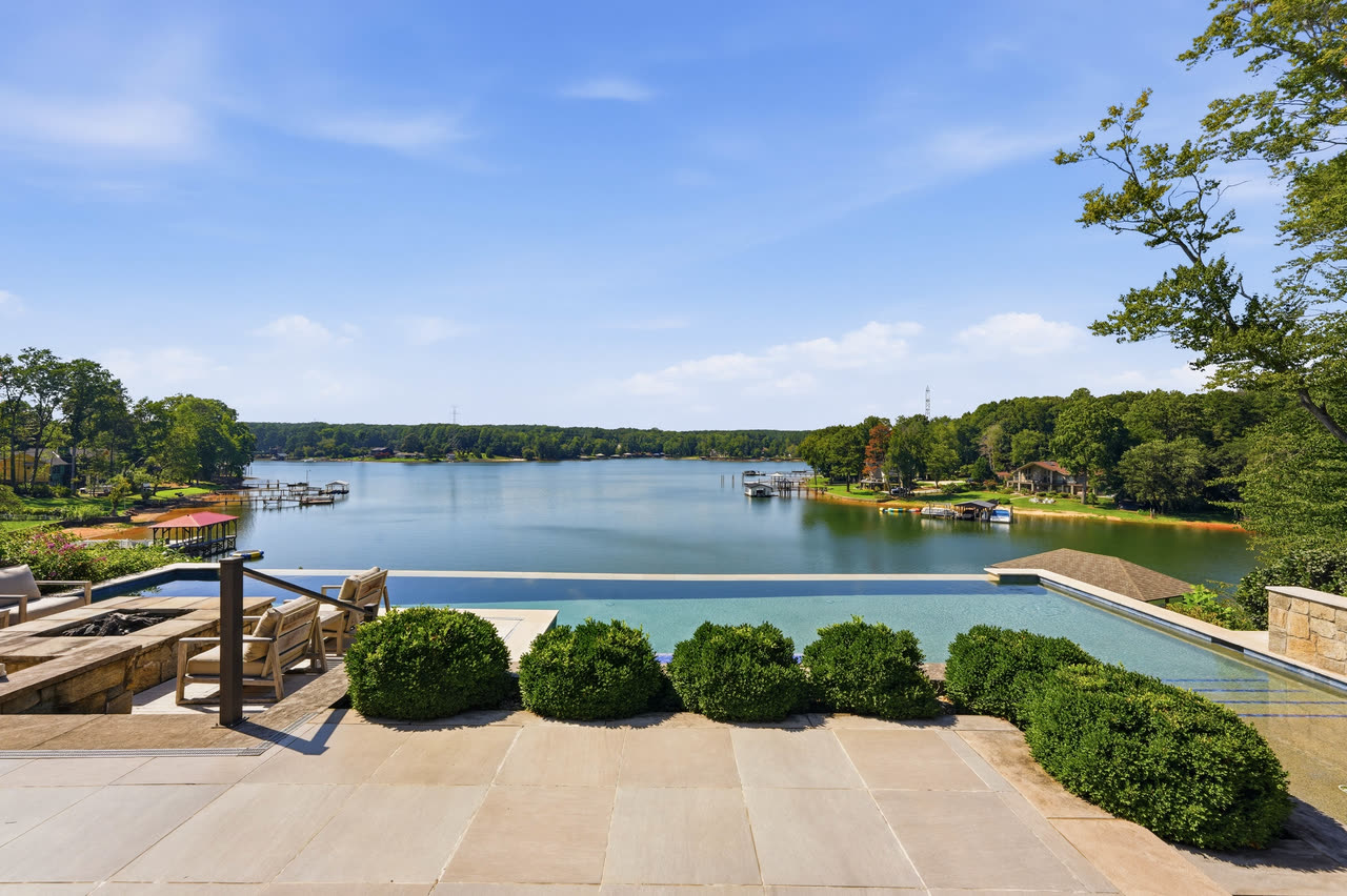 The pool running out toward the lake, clipped hedges along one side.