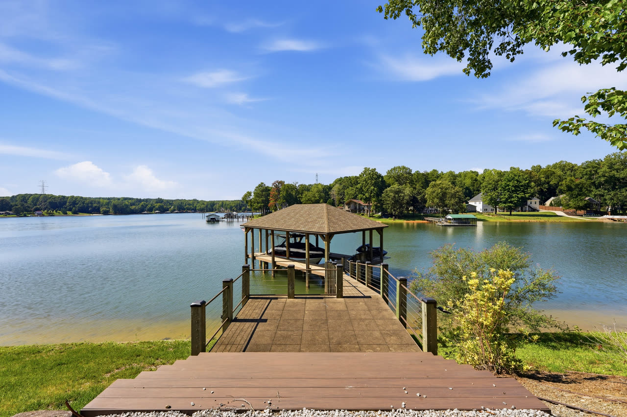 The covered boat dock at the end of its walkway, seen from the lawn.