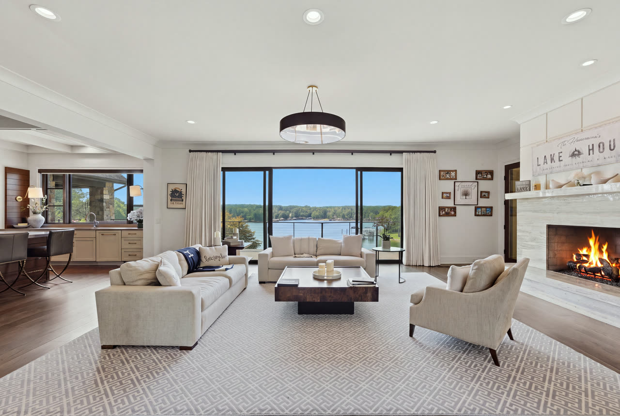 The great room with the fireplace lit and the lake through the far windows.