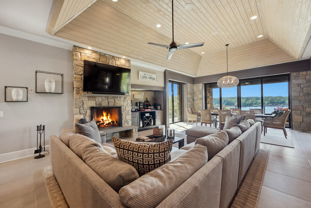 The hearth room with a stone fireplace under a vaulted, boarded ceiling.