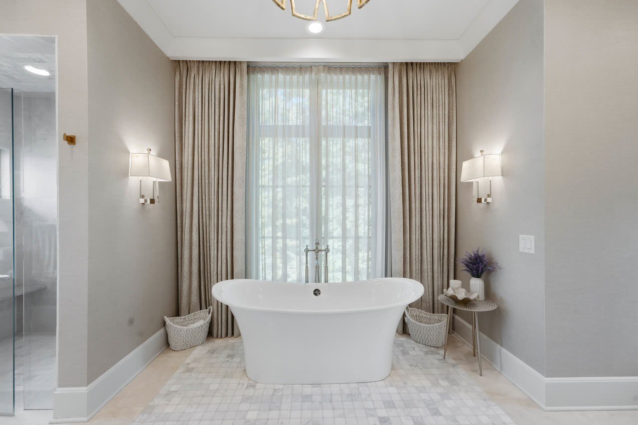 The primary bathroom, a freestanding tub between two sconces.
