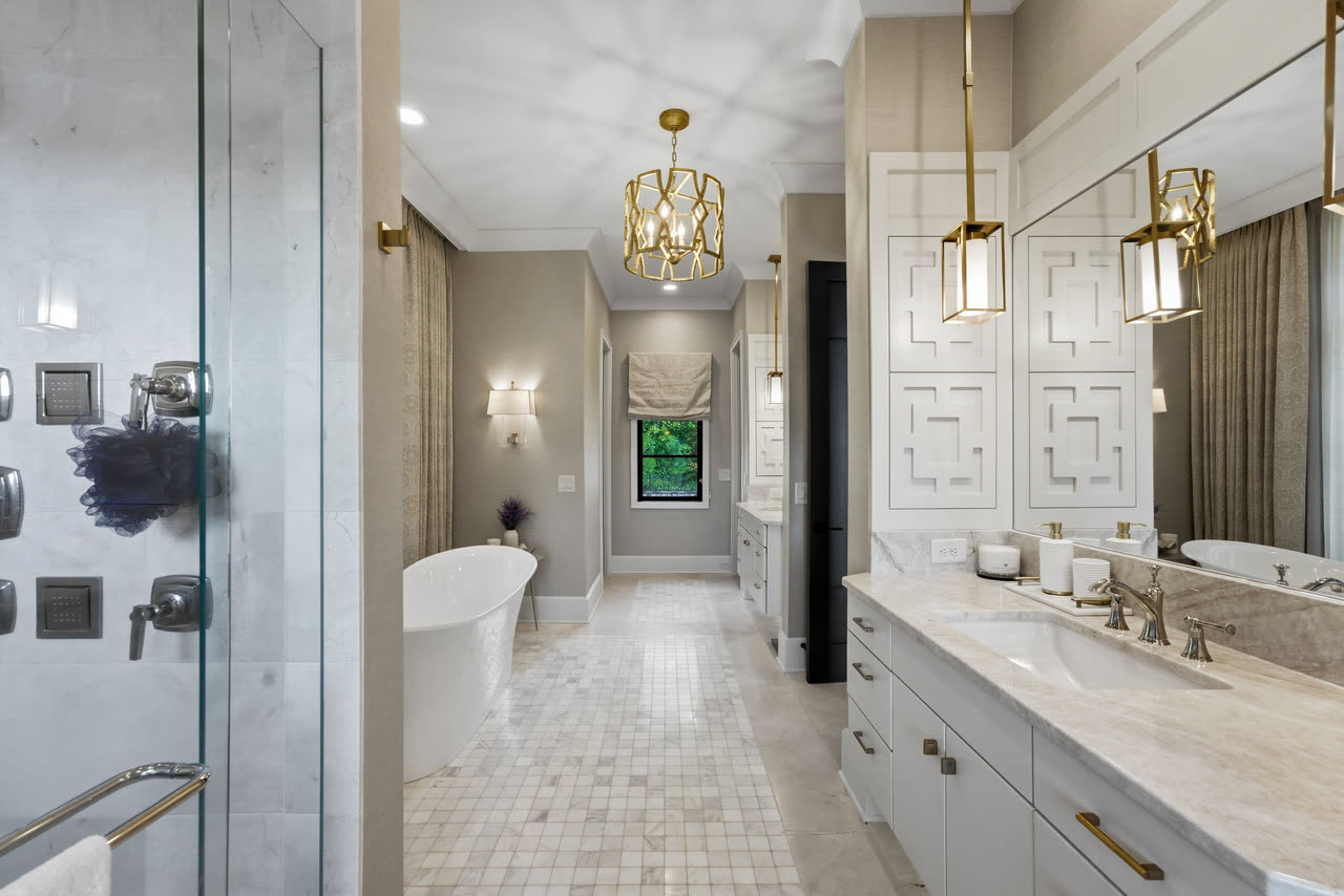 The primary bathroom wide, glass shower on one side and the tub at the end.