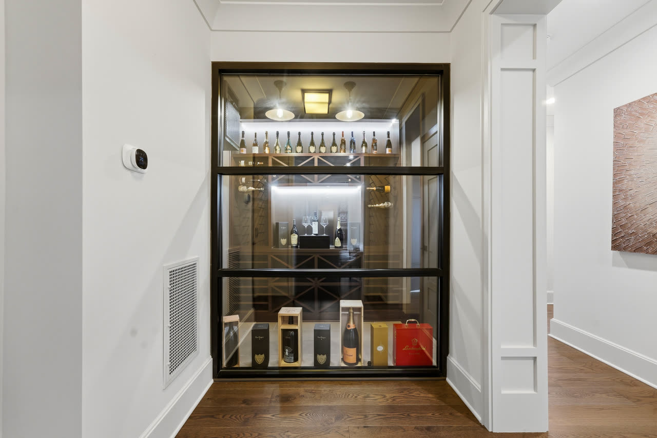 A glass fronted wine display set into the wall of the hall.