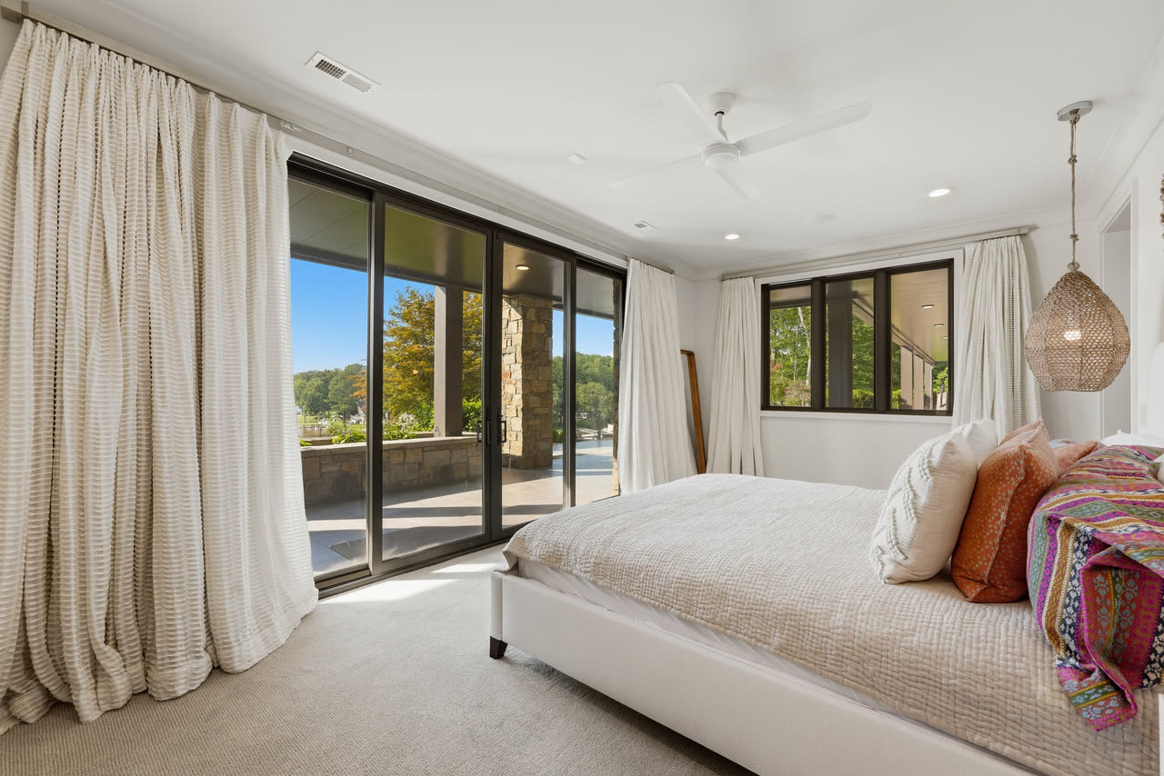 A guest bedroom with full length curtains and doors onto the terrace.